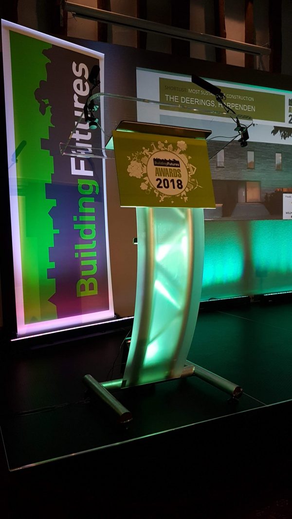 Curved perspex lectern with a foamex board with advertising attached to front.